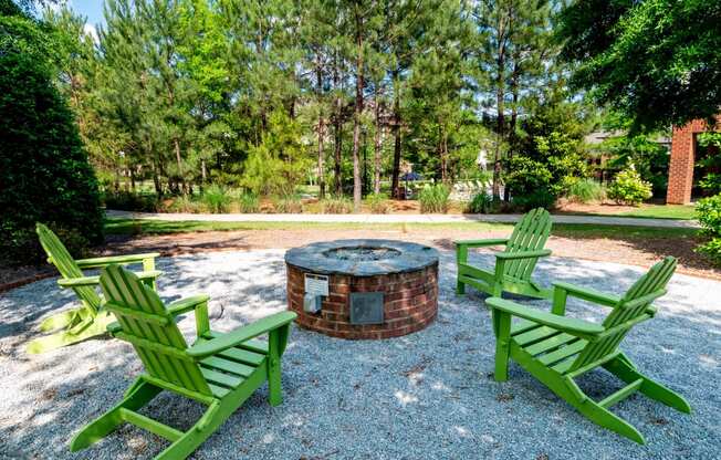 a group of green lawn chairs around a fire pit