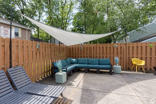 a patio with a blue couch and a canopy over it