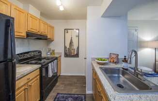 a kitchen with wood cabinets and black appliances