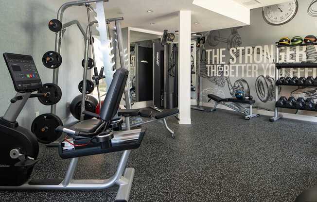 A gym with a variety of equipment including weights and a treadmill.