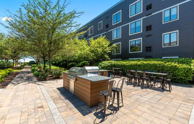 an outdoor patio with tables and chairs in front of an apartment building