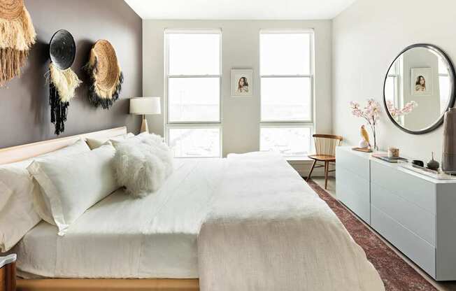 A bedroom with a large bed and a mirror on the wall.
