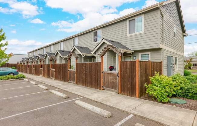 a row of houses with a wooden fence in front of a parking lot