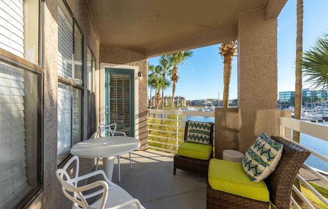 a patio with a table and chairs and a body of water