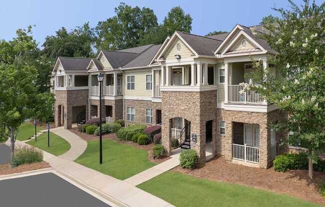 A large, two-story house with a stone facade and a balcony on the second floor.