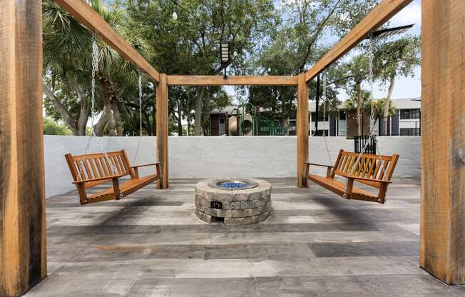 a fire pit in the middle of a patio with benches