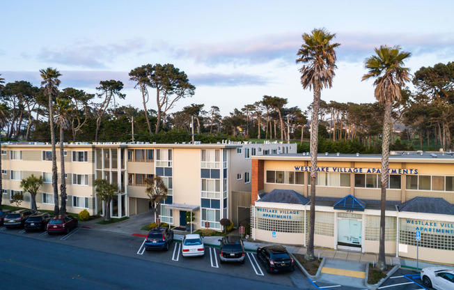 an aerial view of an apartment complex with palm trees in the background