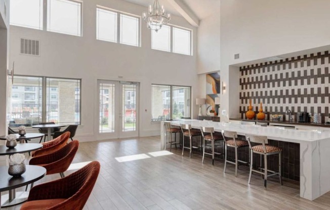 a large room with a bar and chairs