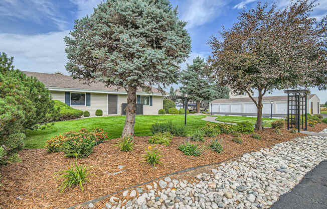 Apartments in Aurora, CO 80011 for Rent – Aurora Meadows - A residential area with a house, trees, and a stone path.