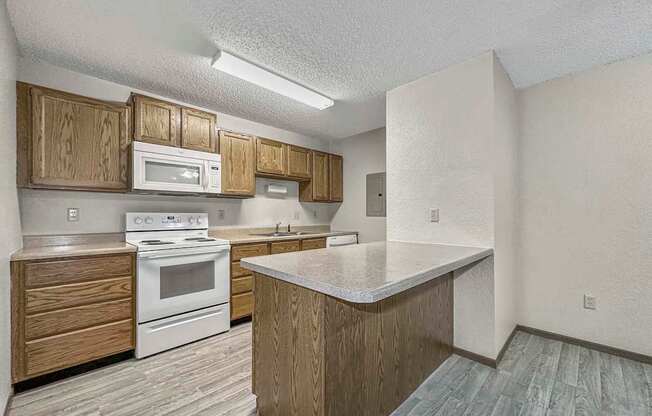 a kitchen with white appliances and wooden cabinets at Creekstone Falls, South Dakota, 57106