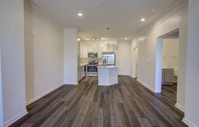 A long hallway with wood floors and white walls.