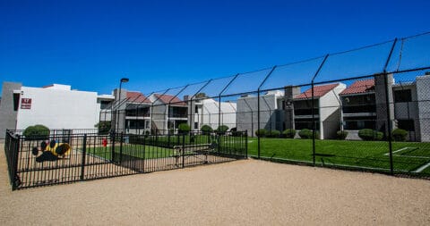 a fenced in area with a playground and buildings