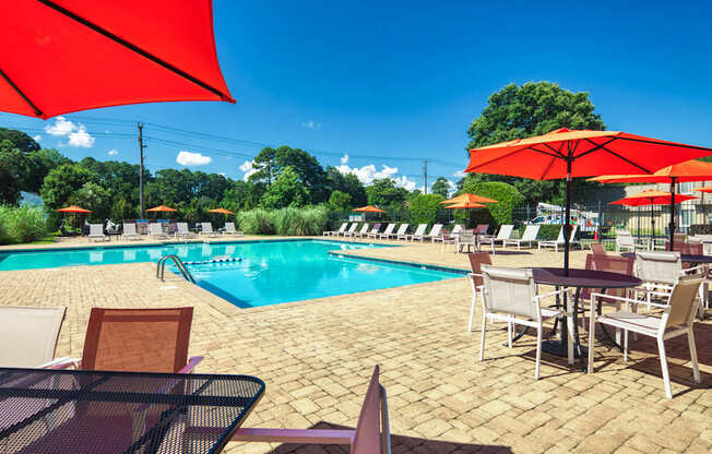 a swimming pool with tables and chairs and umbrellas