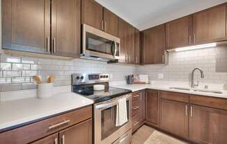 A kitchen with brown cabinets and a white counter.