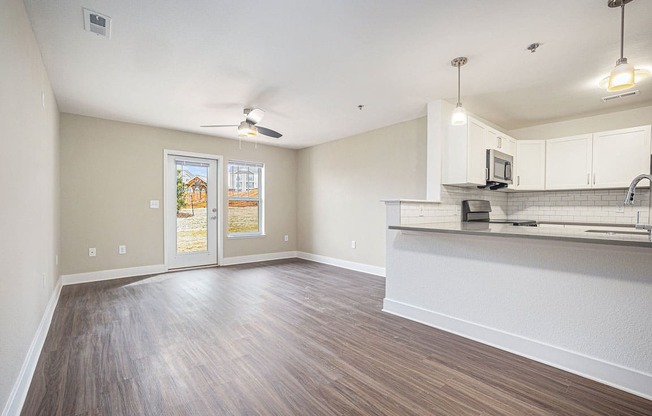 spacious living room and kitchen with a door to a private patio  at Signature Pointe Apartment Homes, Alabama, 35611