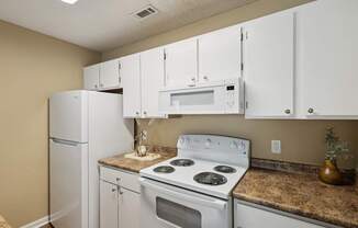 A kitchen with white appliances and cabinets.