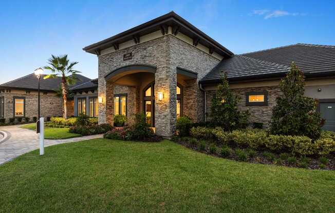 A house with a stone facade and a palm tree in front.