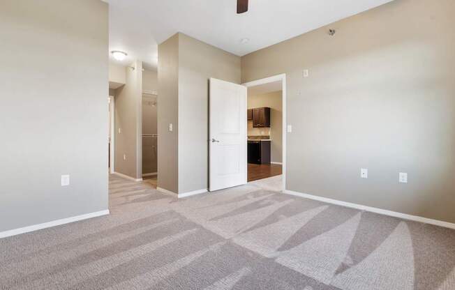 A room with a carpet and a white door.