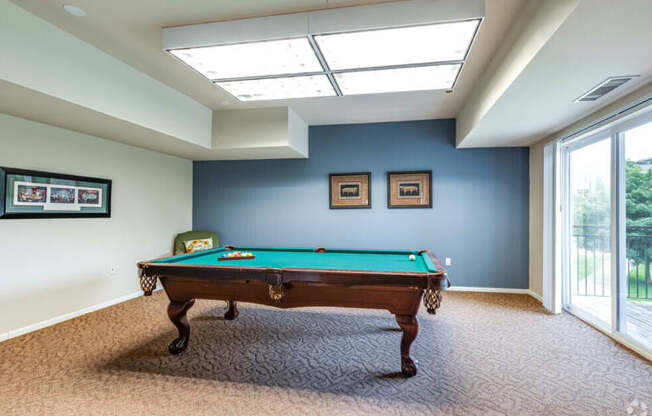 a pool table in a room with a window