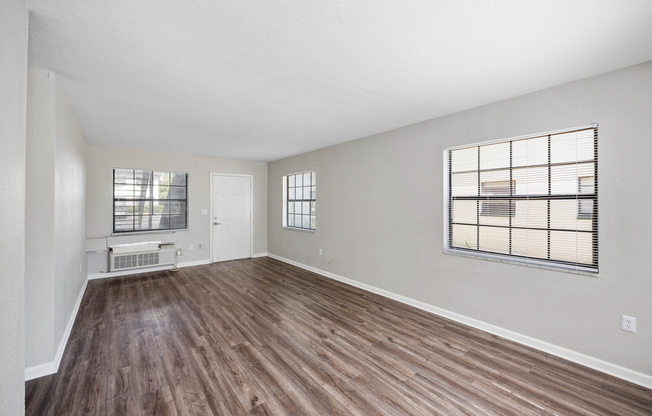 Spacious and bright living area with elegant wooden floors, large windows, and modern finishes.