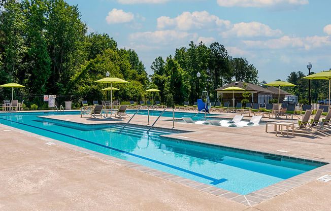 a swimming pool with chairs and umbrellas at the resort