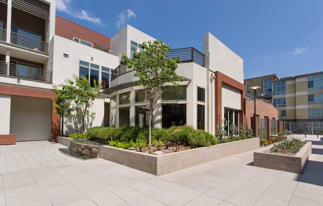 a courtyard with trees and plants in front of a building