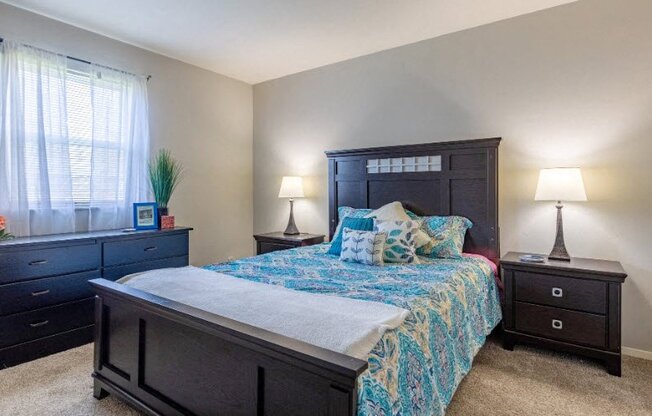 a bedroom with a bed and two dressers