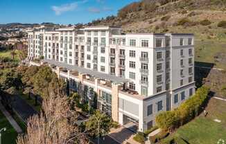 A large white building with a green lawn in front.