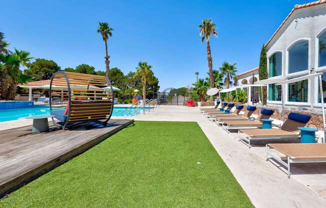 a row of lounge chairs next to a pool at a resort