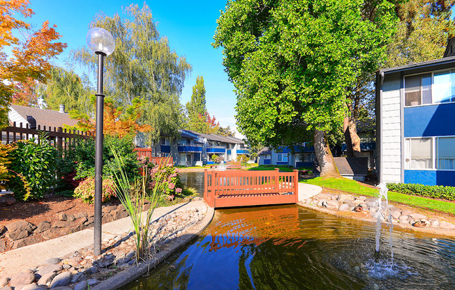 a fenced in pond with a bench in front of a house