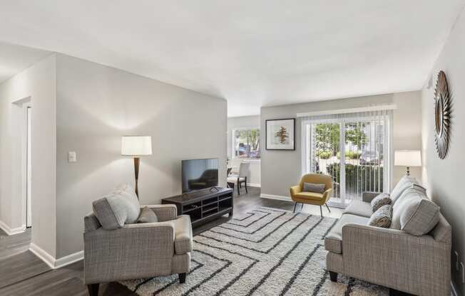 a living room with couches and chairs and a rug