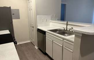 an empty kitchen with a sink and a refrigerator