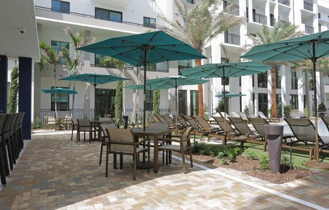 a patio with tables and chairs and umbrellas