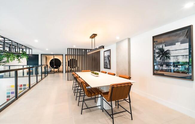Communal dining table with seating for larger gatherings, contemporary lighting, and adjacent coworking spaces designed for collaboration and connection.