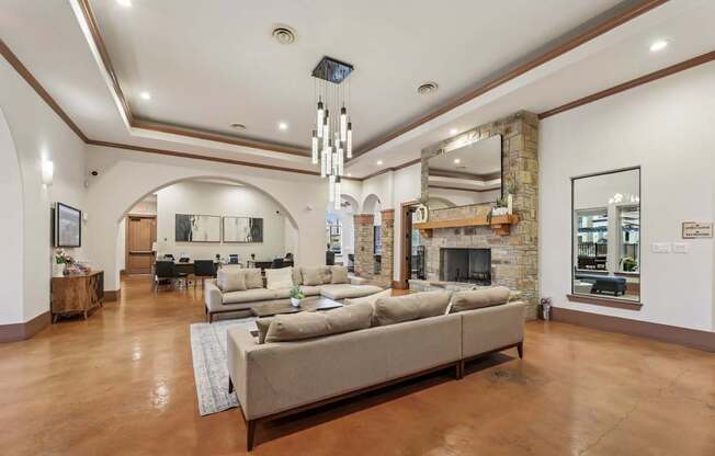A resident lounge with  a large sofa and stone fireplace at Creekside on Parmer Lane Apartments in Austin, TX