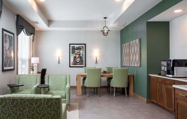 A living room with a green couch and a dining table with chairs.