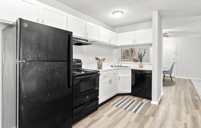Open Kitchen with Black Appliances and White Cabinets at Lakes Edge Apartments, Greensboro, North Carolina