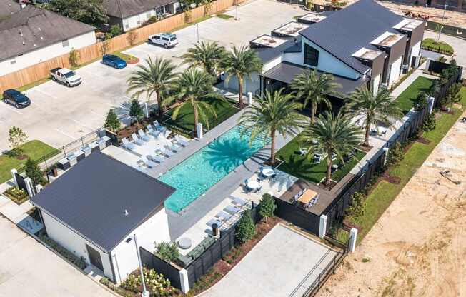 An Apartment Community with a pool and palm trees.