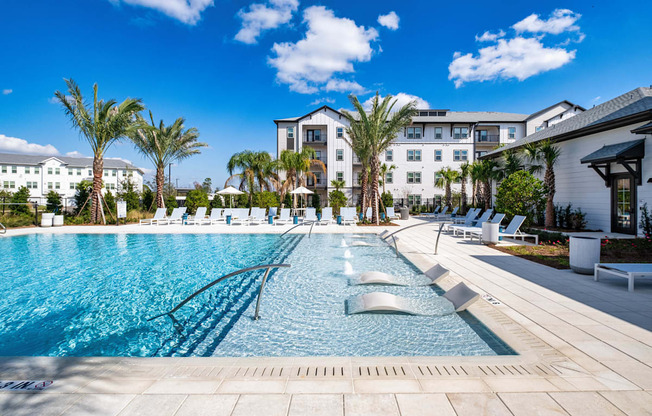 A large swimming pool with a metal railing and a building in the background.