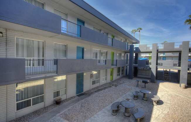 a courtyard with tables and benches outside of a building