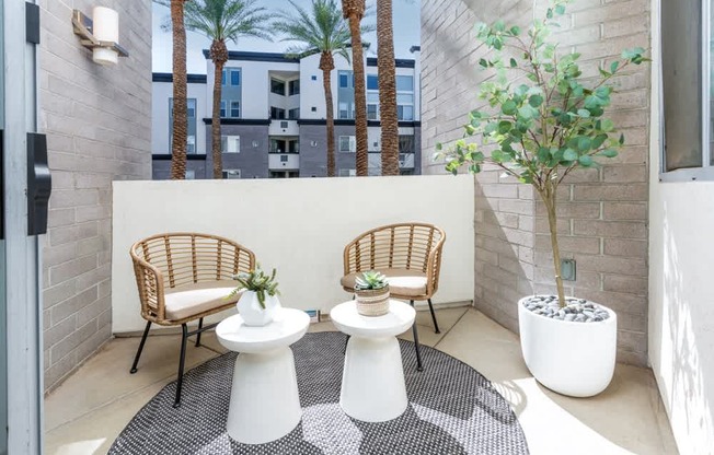 A patio with two chairs and two tables.