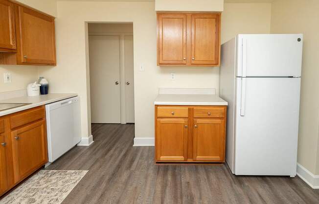 A kitchen with wooden cabinets and a white refrigerator.