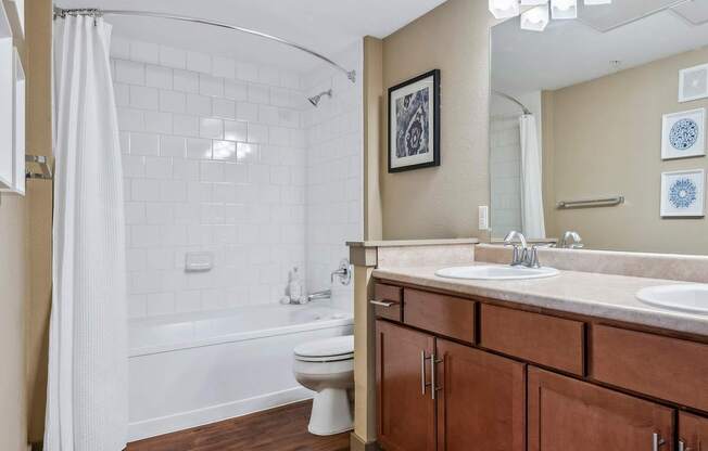 A bathroom with a white toilet and a white bathtub with a shower curtain.