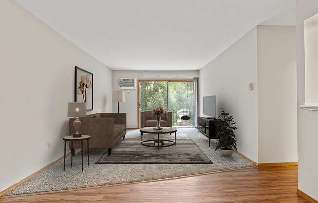 A living room with a brown couch and a rug.