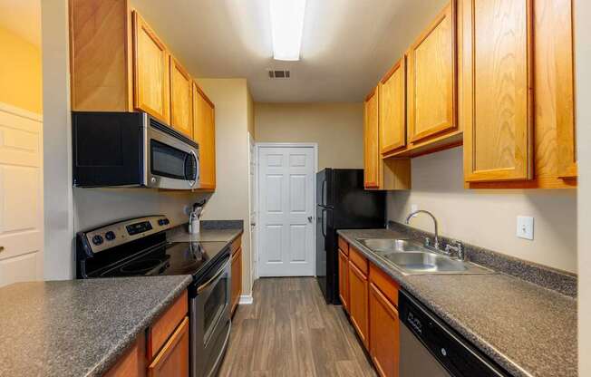 A kitchen with wooden cabinets and black appliances.