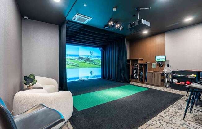 A room with a large screen and a green mat in front of it.