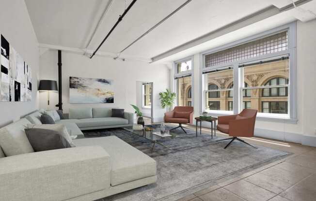 Lofts Downtown LA CA - Santa Fe Lofts - Living Room with Sectional, Coffee Table, Two Chairs, Area Rug, Lamp, and Floor-to-Ceiling Windows.