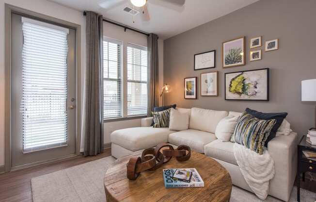 a living room with a white couch and a coffee table with a pair of brown suede at The Whitworth, Williamsburg, VA