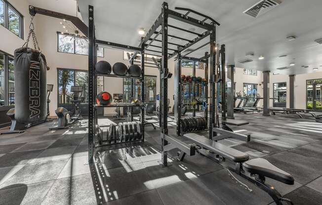 a gym with weights and other equipment in a building with windows