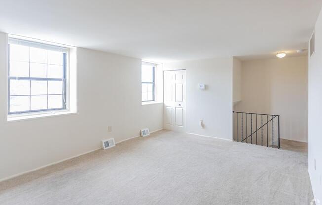 A large empty room with a window and a door.